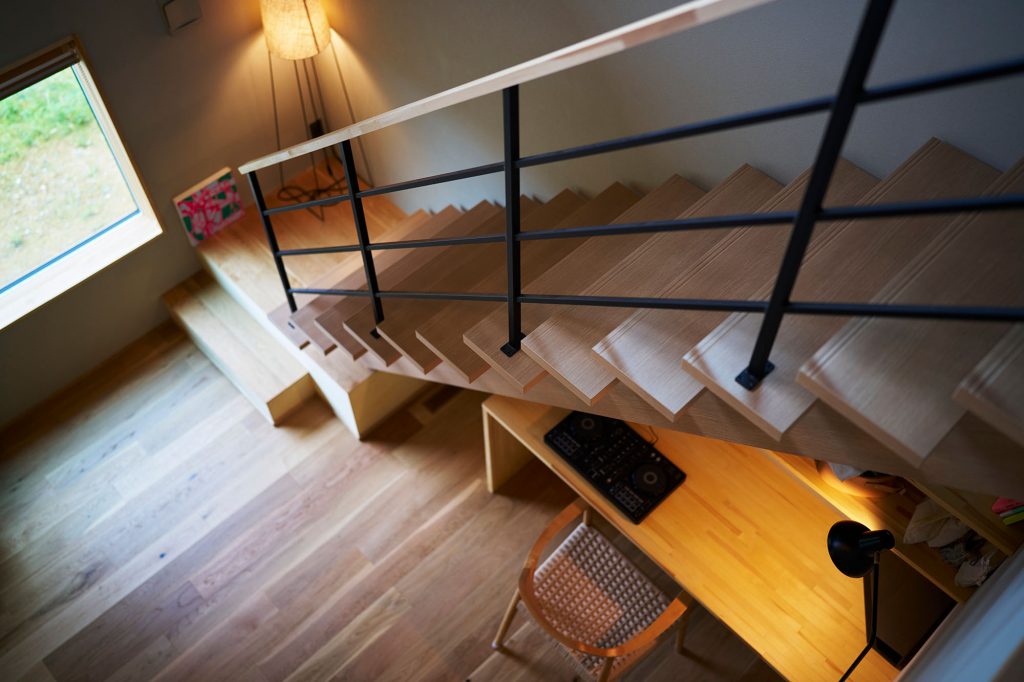 木とアイアンを組み合わせた透かし階段。その下には空間を有効活用してワークスペースを設けた