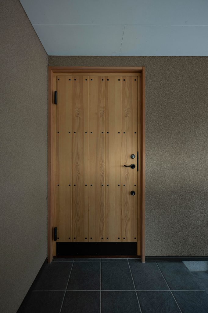 玄関ドアには断熱･気密性に優れた木製の断熱ドアを採用。開け閉めするときのドアの重みに気密性の高さを実感しているそう