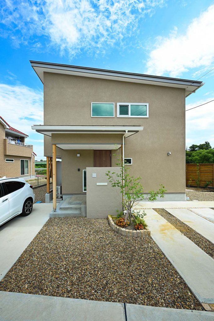 アースカラーの外壁が周囲の景観に溶け込む。南に傾斜する片流れ屋根の上にはソーラーパネルを搭載