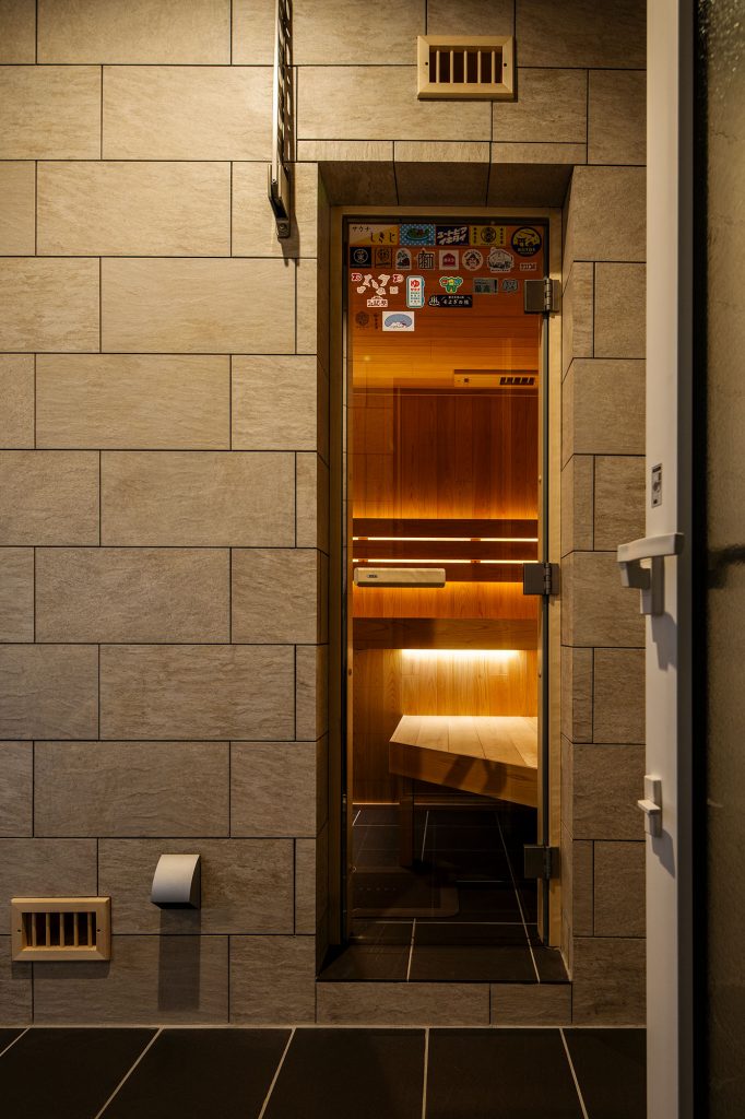 プライベート感あふれるサウナ室。出入り口は、全面ガラスの押し戸になっている